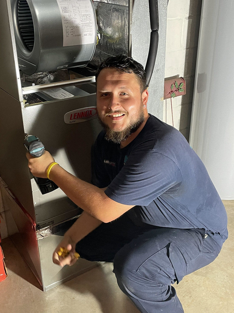 A licensed HVAC technician making a repair inside a home